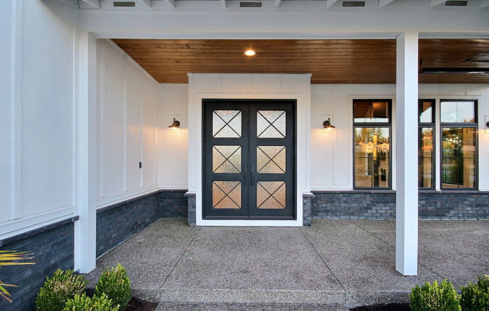 Immagine di una porta d'ingresso country di medie dimensioni con pareti bianche, parquet chiaro, una porta a due ante, una porta nera, pavimento beige e soffitto a volta