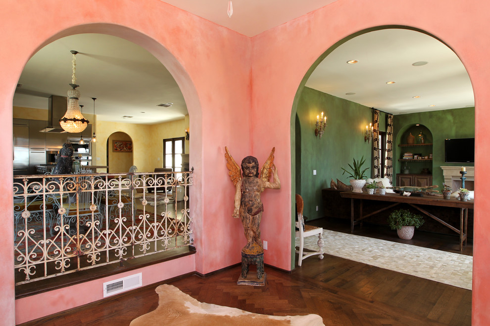На фото: большое фойе в средиземноморском стиле с розовыми стенами, темным паркетным полом, двустворчатой входной дверью, синей входной дверью и коричневым полом с