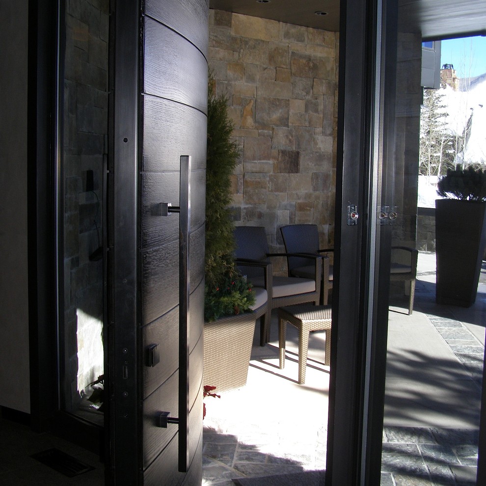 Modern inredning av en entré, med en svart dörr