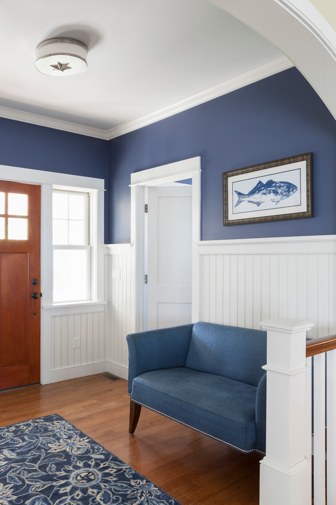 Idee per un ingresso stile marino di medie dimensioni con pareti blu, pavimento in legno massello medio, una porta singola, una porta in legno bruno e pavimento marrone