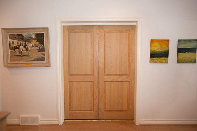 Ejemplo de distribuidor contemporáneo grande con paredes blancas, suelo de madera clara, puerta doble y suelo marrón