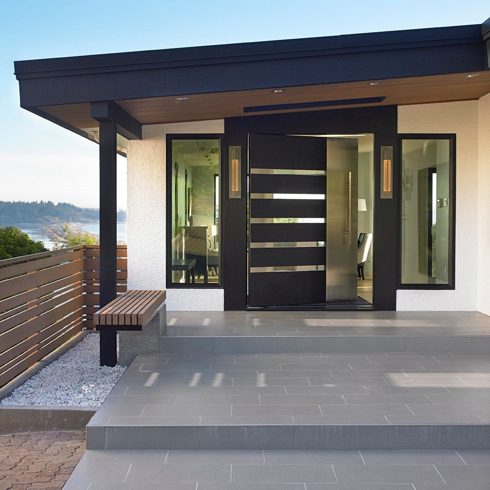 Photo of a medium sized contemporary front door in Vancouver with white walls, porcelain flooring, a pivot front door and a black front door.