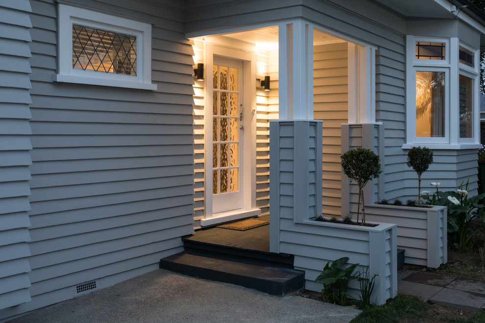 Kleine Moderne Haustür mit grauer Wandfarbe, gebeiztem Holzboden, Einzeltür, Haustür aus Glas und schwarzem Boden in Auckland