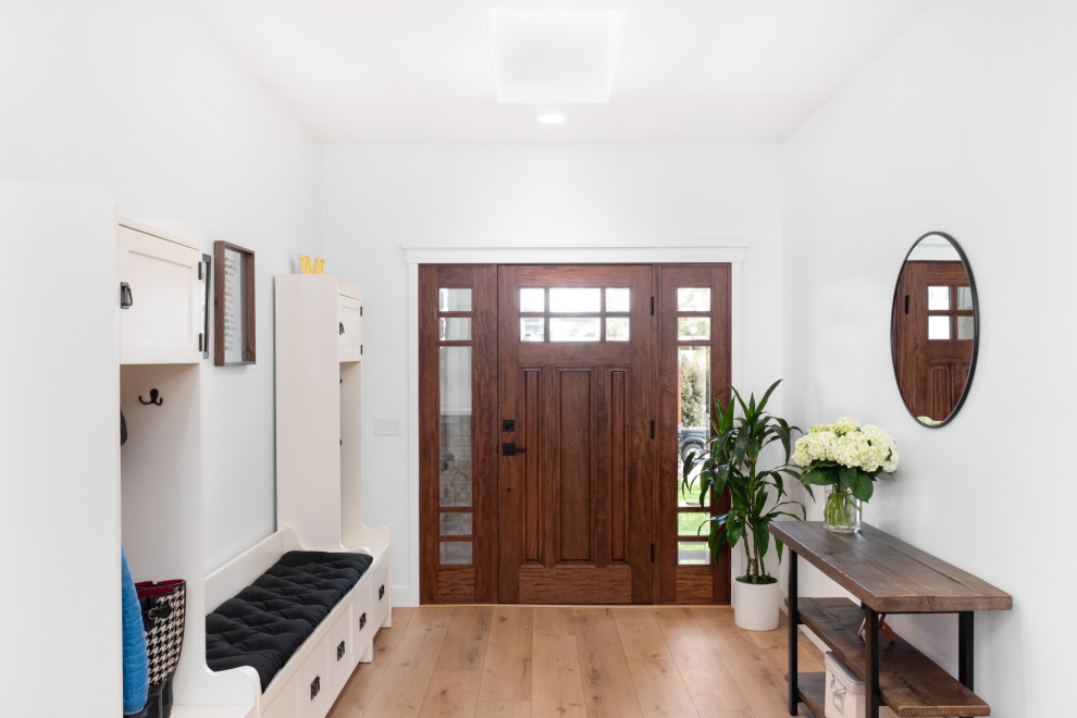 Entryway - huge contemporary medium tone wood floor and brown floor entryway idea in San Diego with white walls and a dark wood front door