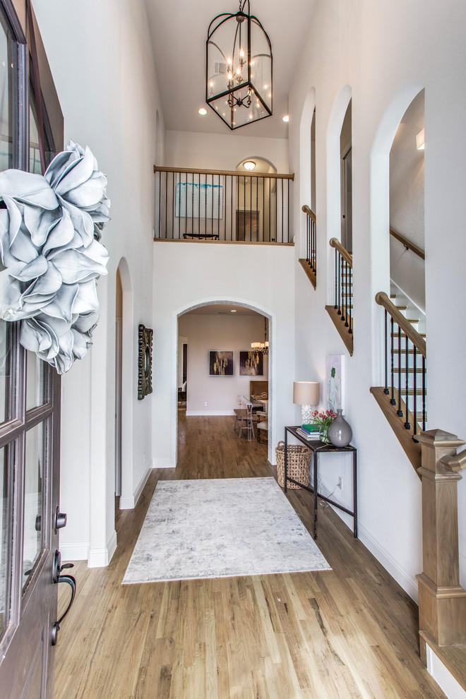 Entryway - mid-sized traditional medium tone wood floor and white floor entryway idea in Dallas with white walls and a brown front door