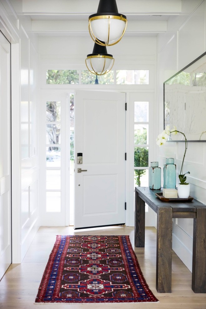 Inspiration for a mid-sized transitional light wood floor entryway remodel in San Francisco with white walls and a white front door