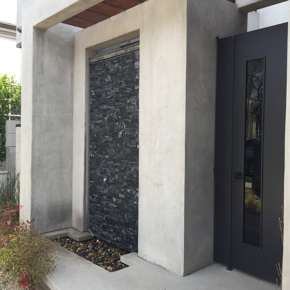 Bild på en mellanstor funkis ingång och ytterdörr, med grå väggar, betonggolv, en enkeldörr och glasdörr