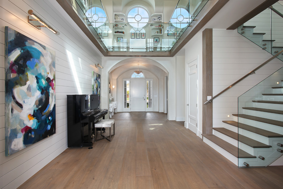Geräumiges Maritimes Foyer mit weißer Wandfarbe, braunem Holzboden, Einzeltür und weißer Haustür in Orange County