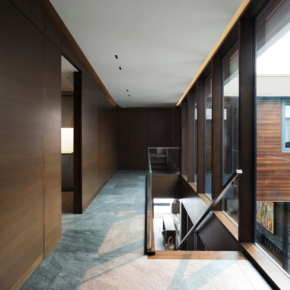 Idée de décoration pour un petit hall d'entrée design avec un mur marron, un sol en linoléum, une porte pivot, une porte en bois foncé et un sol gris.