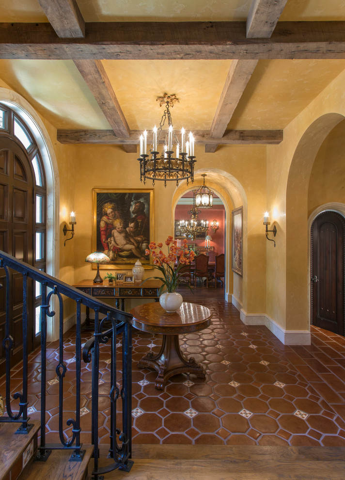 Mittelgroßes Mediterranes Foyer mit beiger Wandfarbe, Terrakottaboden, dunkler Holzhaustür, Einzeltür und braunem Boden in Miami