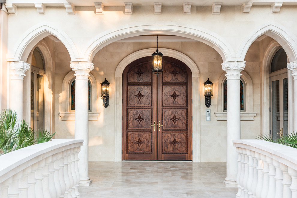 Photo of a mediterranean entrance in Miami with a double front door and a dark wood front door.
