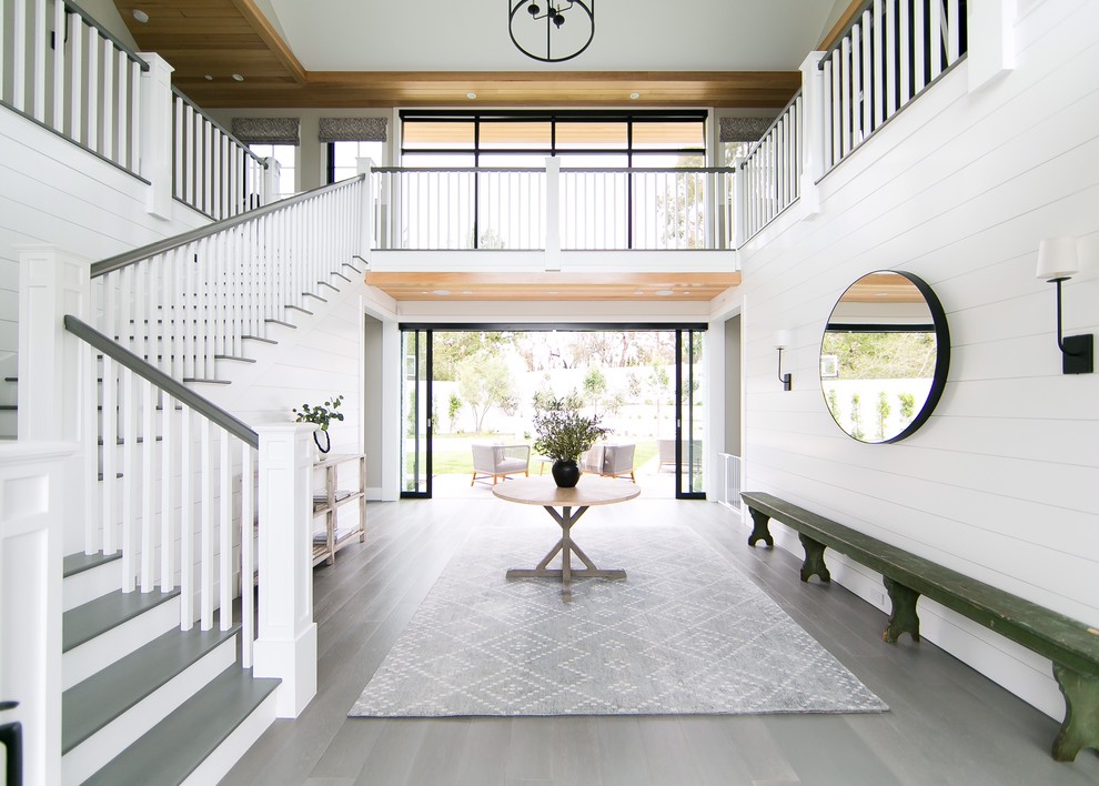 Mittelgroßes Klassisches Foyer mit weißer Wandfarbe, grauem Boden und braunem Holzboden in Orange County