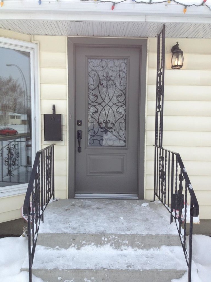 Diseño de puerta principal clásica de tamaño medio con paredes beige, puerta simple y puerta gris