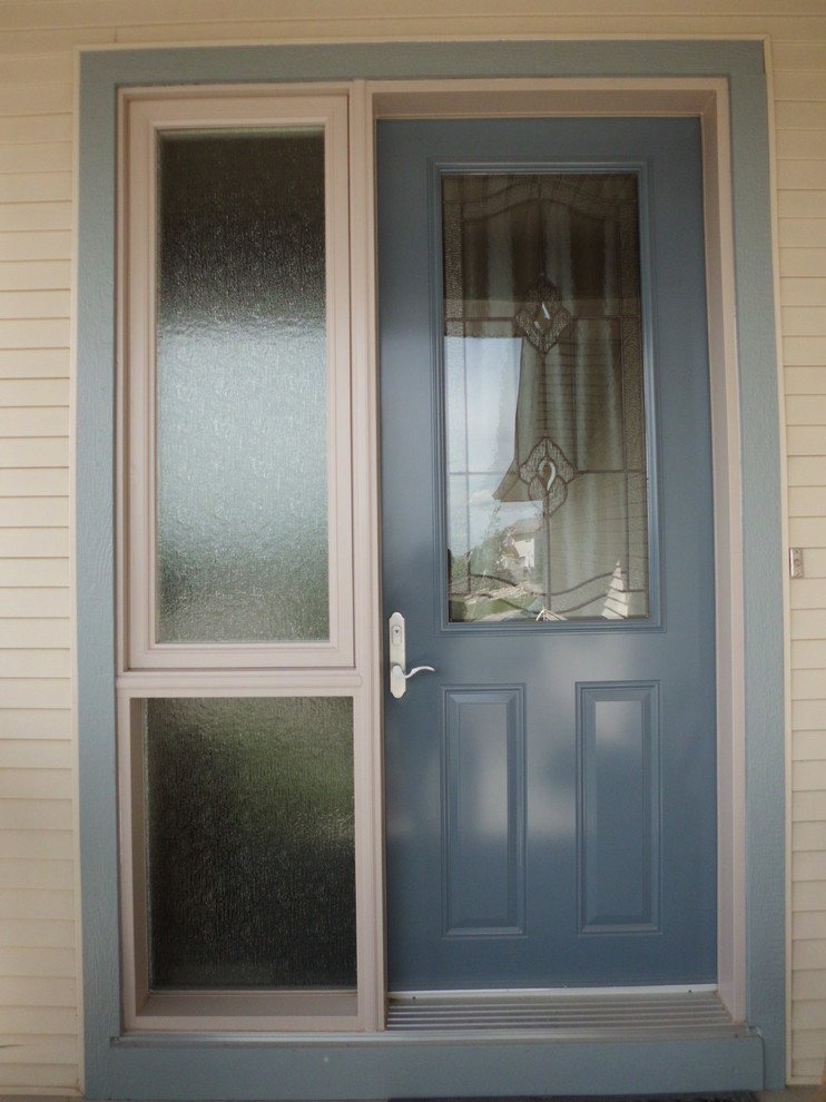 На фото: входная дверь в классическом стиле с бежевыми стенами, одностворчатой входной дверью и синей входной дверью с