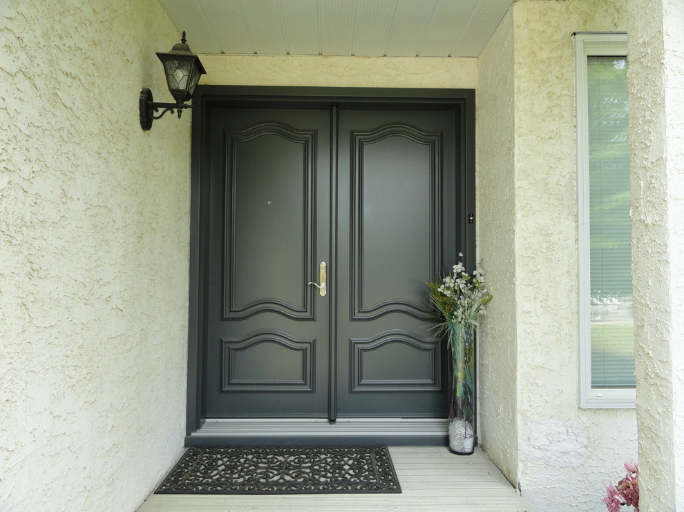 Modelo de puerta principal tradicional grande con paredes blancas, puerta doble y puerta gris