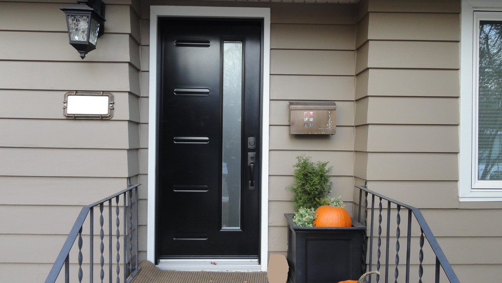 На фото: входная дверь среднего размера в стиле неоклассика (современная классика) с коричневыми стенами, одностворчатой входной дверью и черной входной дверью