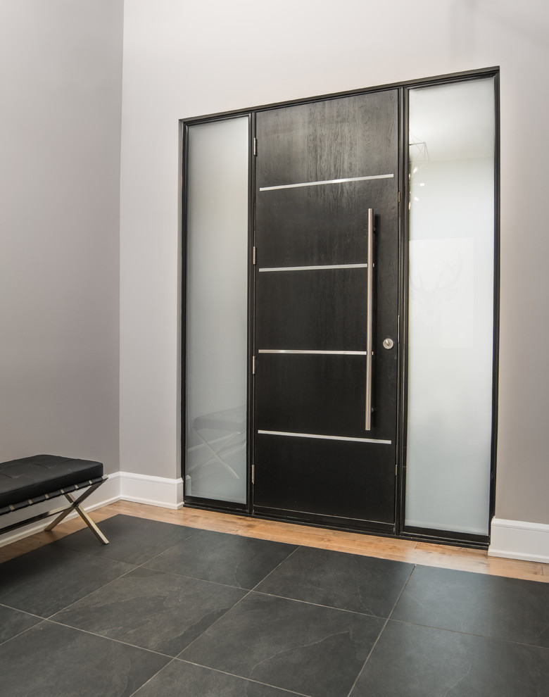 Example of a mid-sized trendy ceramic tile and black floor entryway design in Montreal with gray walls and a black front door