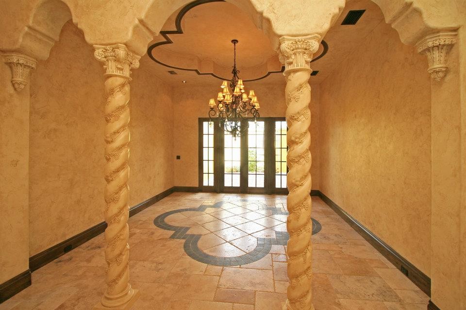 Idée de décoration pour un grand hall d'entrée méditerranéen avec un mur beige, un sol en travertin, une porte double, une porte en verre et un sol beige.