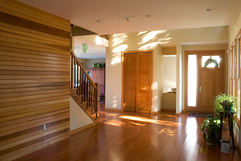 Foto på en stor funkis ingång och ytterdörr, med beige väggar, ljust trägolv, en enkeldörr, ljus trädörr och brunt golv