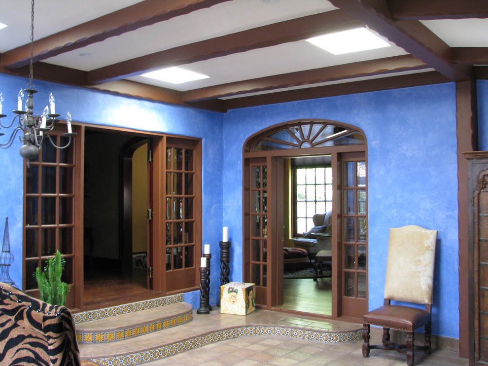 フェニックスにある高級な中くらいなサンタフェスタイルのおしゃれな玄関ロビー (青い壁、茶色いドア) の写真