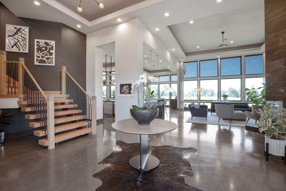 This is an example of a large contemporary foyer in Portland with white walls, concrete flooring, grey floors, a drop ceiling and wallpapered walls.