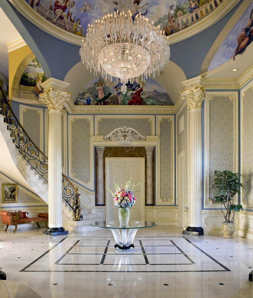 Exemple d'un très grand hall d'entrée chic avec un mur bleu et un sol en marbre.