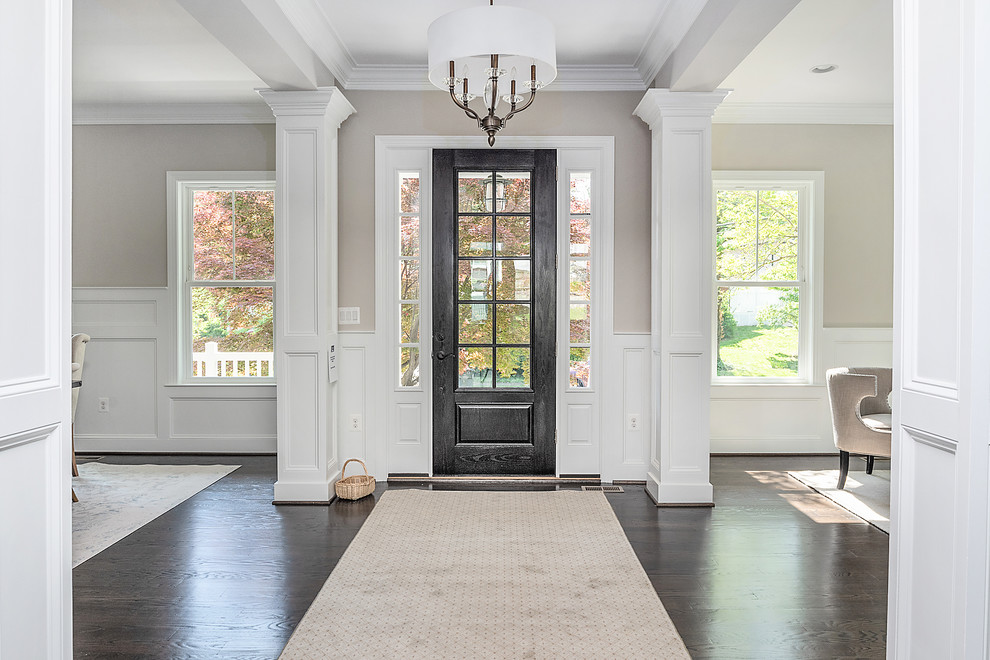 Diseño de puerta principal tradicional renovada con paredes beige, suelo de madera oscura, puerta simple, puerta de madera oscura y suelo marrón