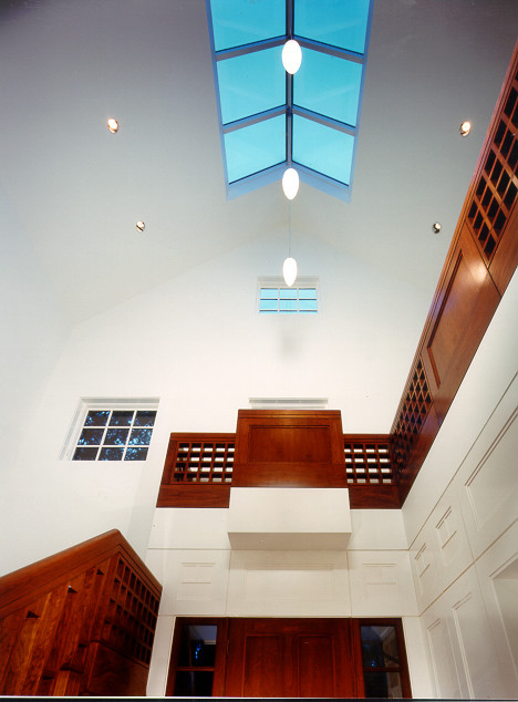 Example of a large minimalist medium tone wood floor foyer design in Los Angeles with white walls