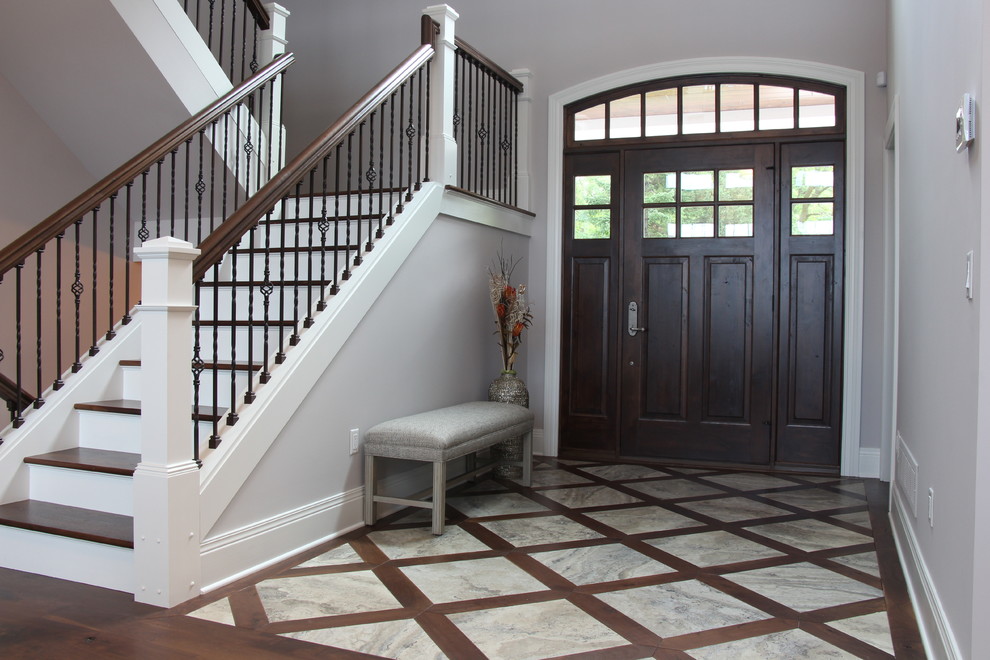 Idee per un grande ingresso tradizionale con pareti grigie, pavimento in gres porcellanato, una porta singola, una porta in legno scuro e pavimento grigio