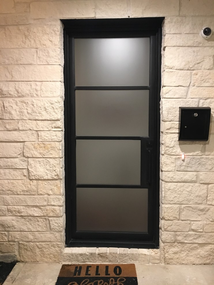 This is an example of a medium sized contemporary front door in Houston with a single front door and a glass front door.