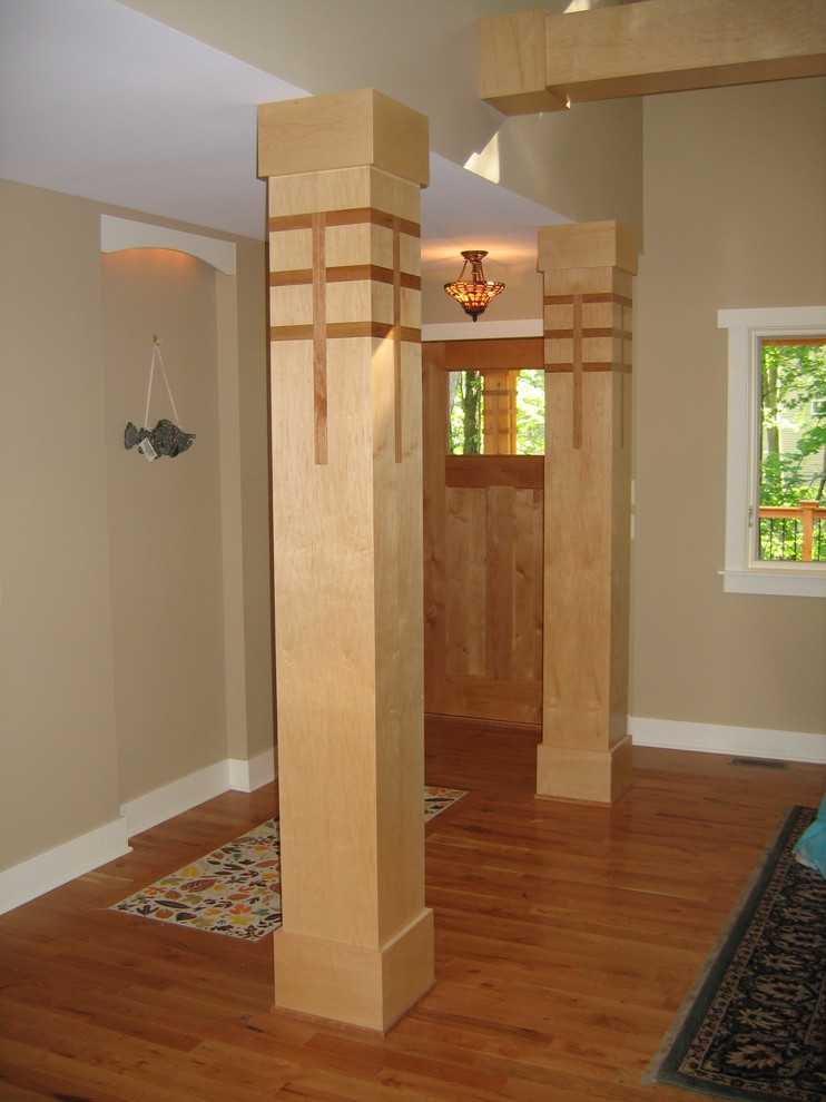 Réalisation d'une porte d'entrée design de taille moyenne avec un mur beige, un sol en bois brun, une porte simple et une porte en bois clair.