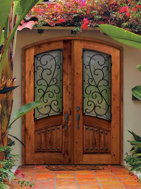 タンパにある高級な広い地中海スタイルのおしゃれな玄関ドア (ベージュの壁、淡色木目調のドア) の写真