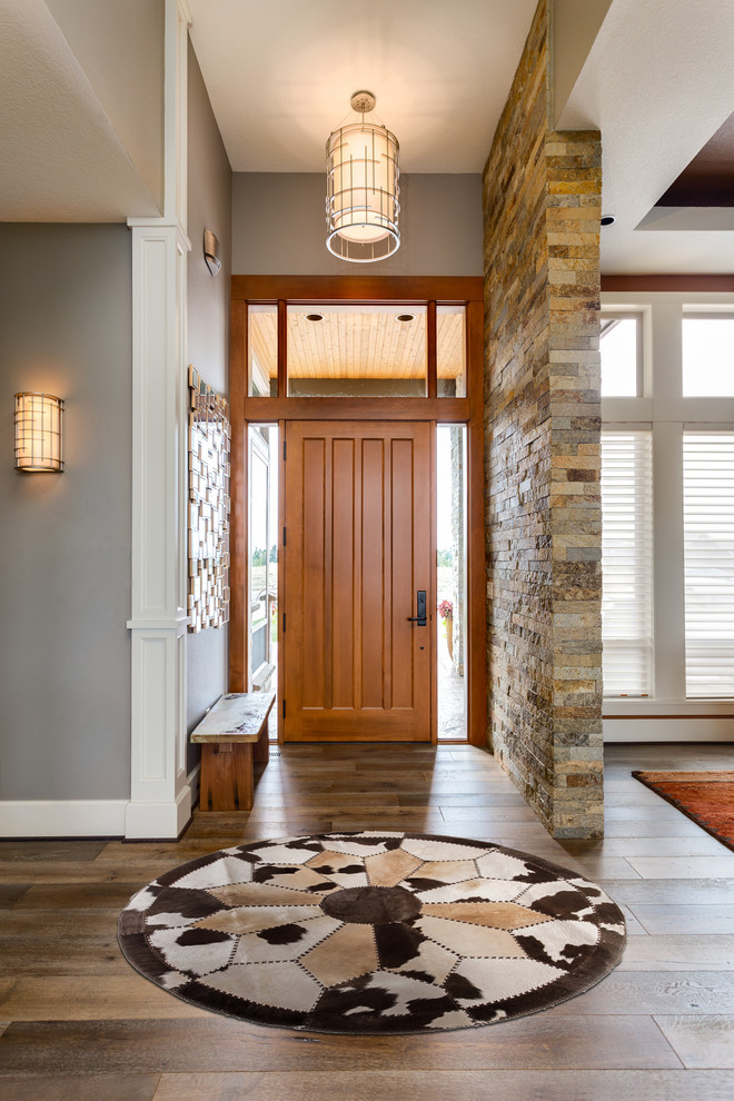 Diseño de puerta principal minimalista de tamaño medio con paredes grises, suelo de madera en tonos medios, puerta simple, puerta de madera clara y suelo marrón