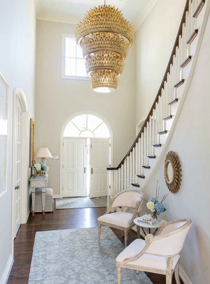 ダラスにあるラグジュアリーな広いトランジショナルスタイルのおしゃれな玄関ロビー (グレーの壁、濃色無垢フローリング、白いドア、茶色い床) の写真