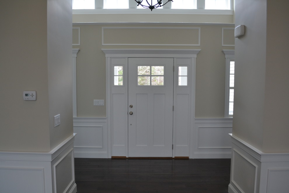 Réalisation d'un hall d'entrée tradition de taille moyenne avec un mur beige, parquet foncé, une porte simple et une porte blanche.