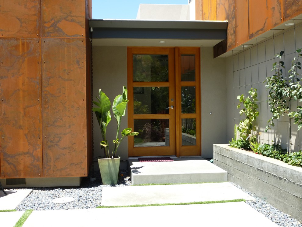 Ispirazione per una porta d'ingresso minimalista di medie dimensioni con pareti beige, pavimento in cemento, una porta singola e una porta in legno bruno