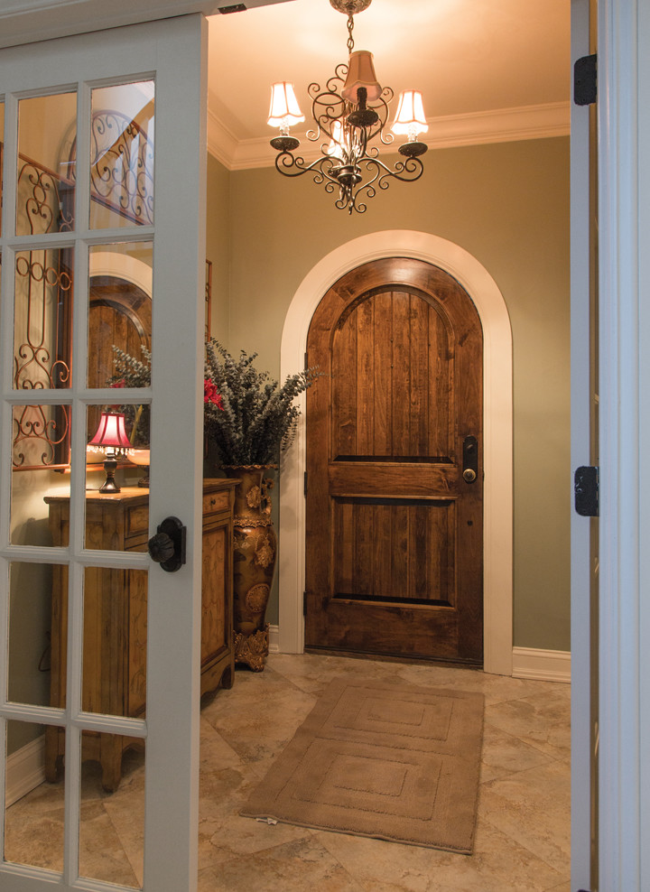 На фото: фойе среднего размера в классическом стиле с зелеными стенами, полом из керамогранита, одностворчатой входной дверью и входной дверью из дерева среднего тона с