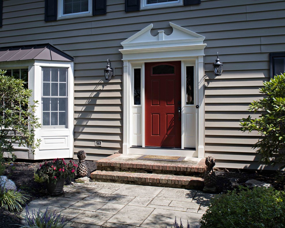 Diseño de puerta principal tradicional grande con paredes beige, suelo de baldosas de porcelana, puerta simple y puerta roja
