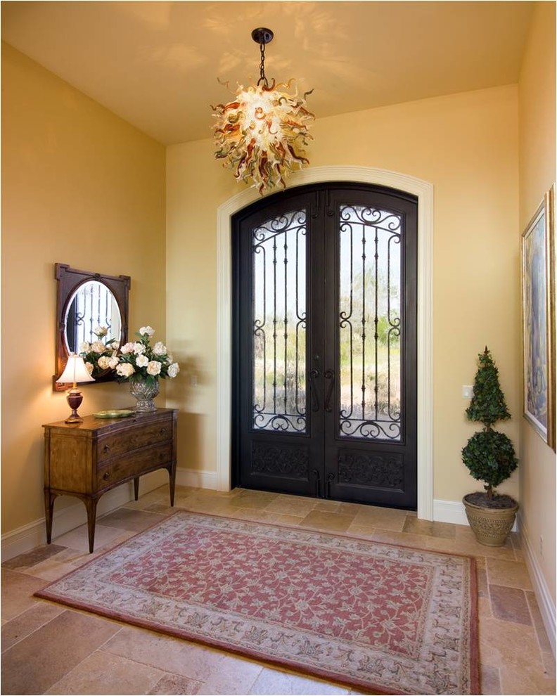 Mediterranean entrance in Miami with a double front door and a metal front door.