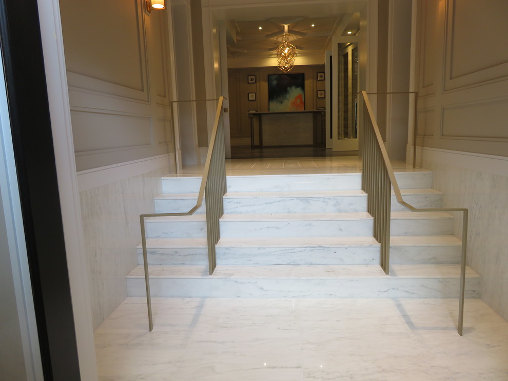 Idées déco pour un grand hall d'entrée moderne avec un sol en marbre et un mur beige.