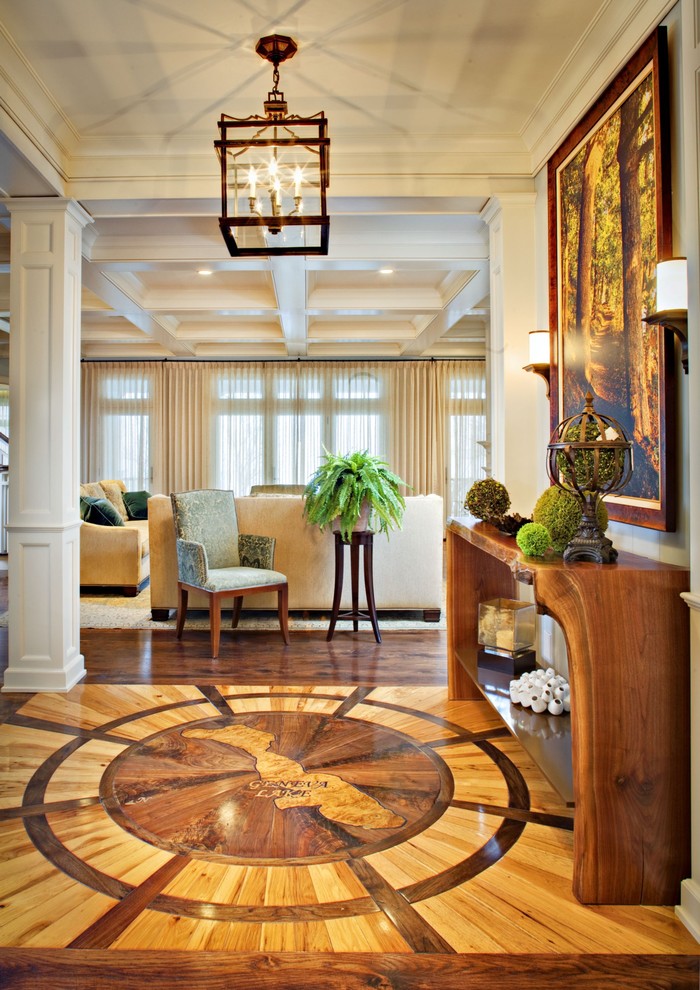 Idée de décoration pour un grand hall d'entrée tradition avec un sol en bois brun et un mur blanc.