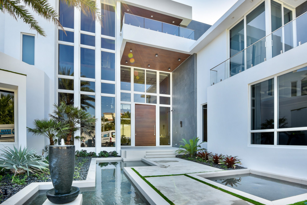Große Moderne Haustür mit weißer Wandfarbe, Betonboden, Drehtür, brauner Haustür, grauem Boden und Holzdecke in Miami