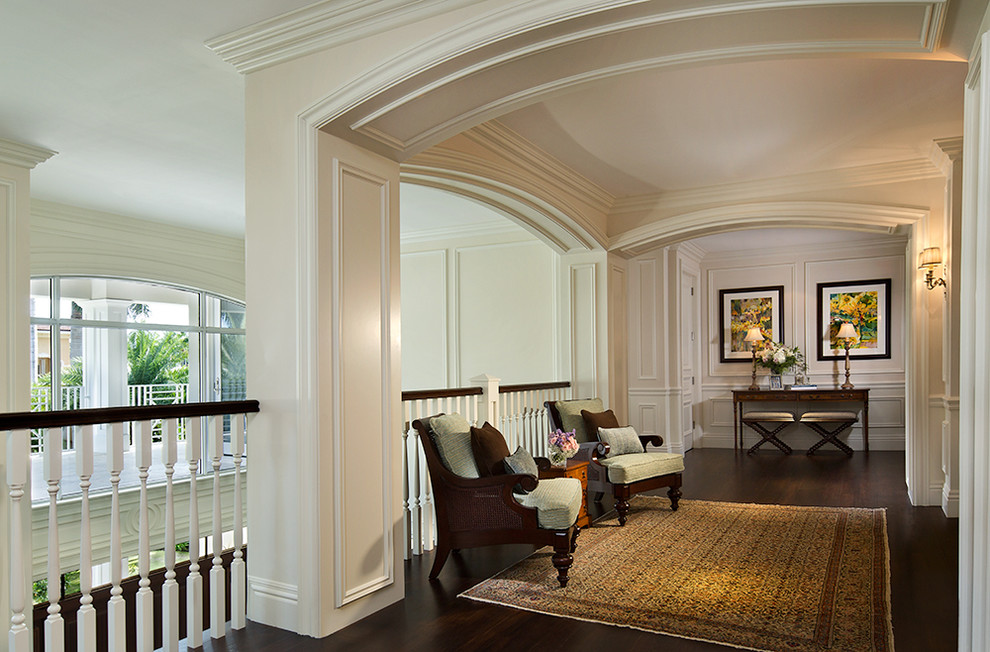 Exempel på en stor klassisk foajé, med vita väggar, mörkt trägolv, en dubbeldörr, en vit dörr och brunt golv