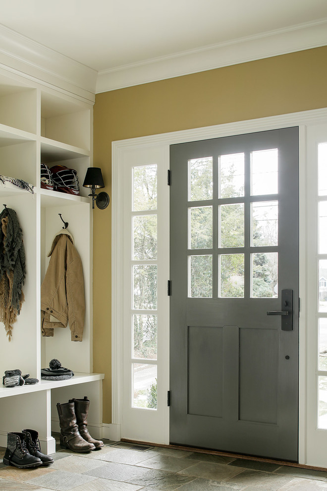 На фото: тамбур среднего размера в классическом стиле с коричневыми стенами, полом из керамогранита, одностворчатой входной дверью и серой входной дверью с
