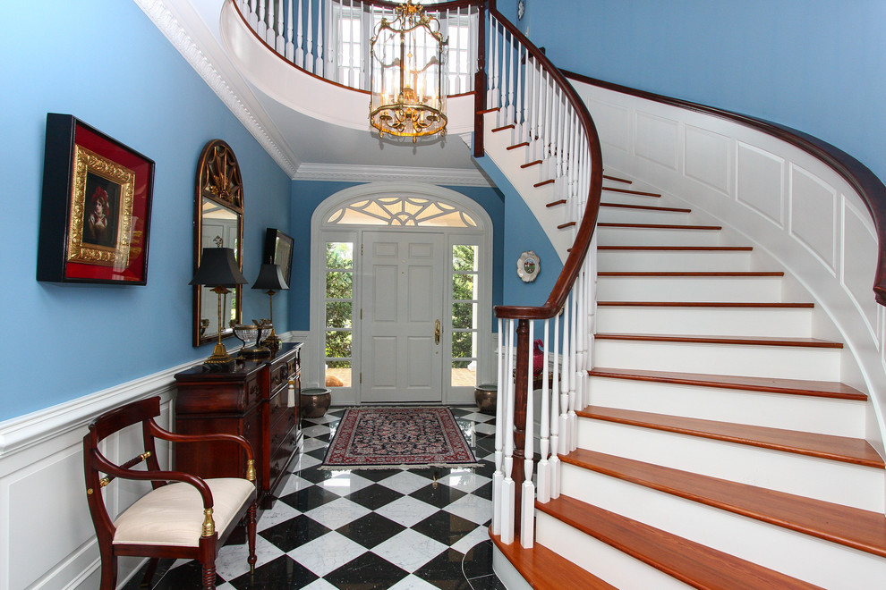 На фото: фойе в классическом стиле с синими стенами, одностворчатой входной дверью и белой входной дверью