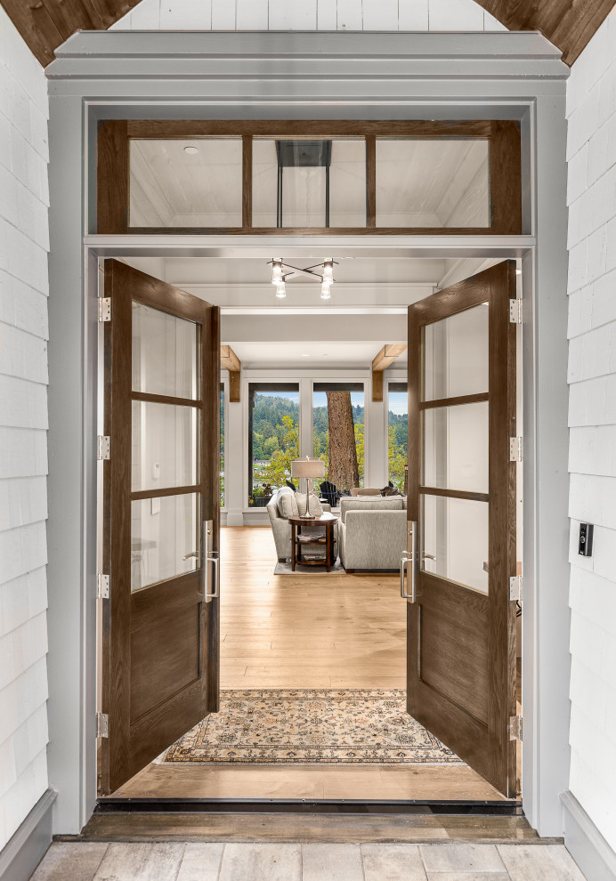 Cette photo montre une grande porte d'entrée chic avec un mur gris, parquet clair, une porte double et une porte en verre.