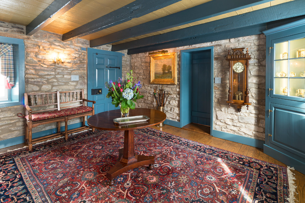 Idee per un ampio ingresso country con pavimento in legno massello medio, una porta singola e una porta blu