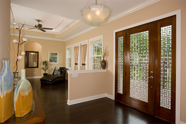 Mittelgroße Haustür mit beiger Wandfarbe, dunklem Holzboden, Einzeltür und Haustür aus Glas in Tampa