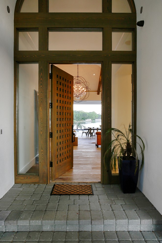 Ejemplo de puerta principal actual grande con paredes blancas, suelo de madera clara, puerta simple, puerta de vidrio y suelo marrón