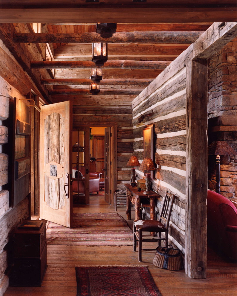 Inspiration pour un grand hall d'entrée chalet avec un sol en bois brun, une porte simple et une porte en bois clair.